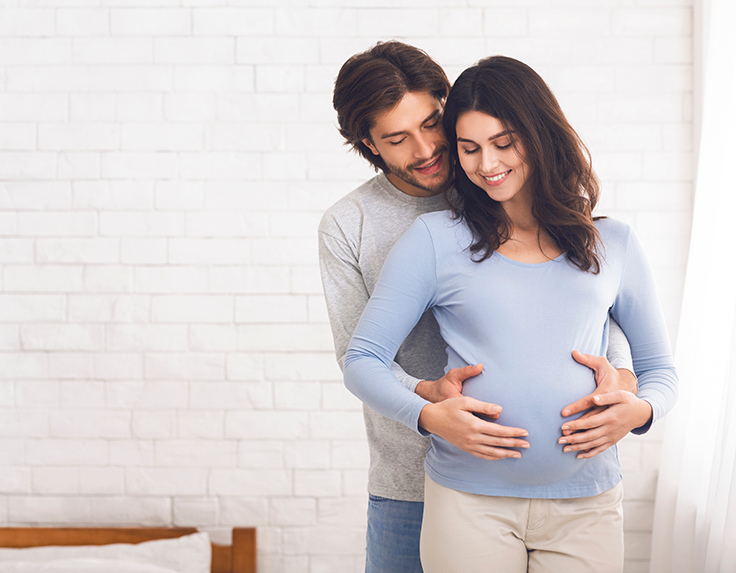 Man tightly holding a pregnant women 